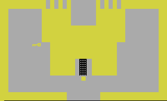 The start of Adventure: the gold castle with its portcullis closed, the gold key on the left and the player's square below the gate.