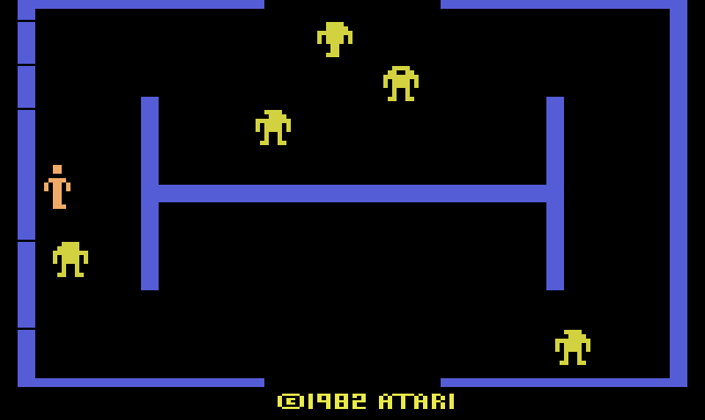 The first room of Berzerk: blue maze walls, yellow robots, the orange player at the left and ©1982 Atari at the bottom.