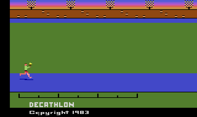 The title screen: an athlete carrying the torch along the blue track below the stands, and DECATHLON, Copyright 1983.